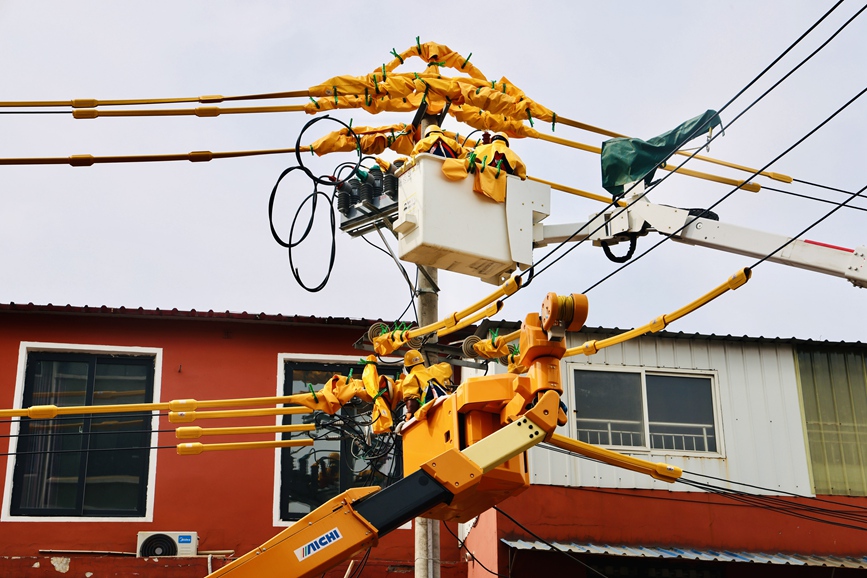 河南洛陽孟津供電公司帶電作業(yè)人員在10千伏麻水線開展帶電加裝柱上開關(guān)作業(yè)。劉偉韜 攝