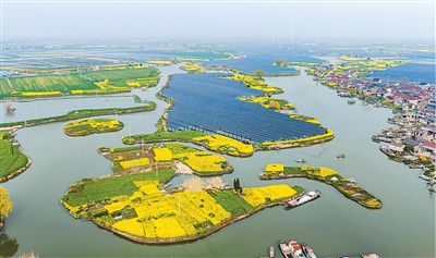 工作人員在江蘇泰州海陵區(qū)華港鎮(zhèn)下溪村乘船巡檢水上光伏設(shè)備。湯德宏攝（人民視覺）
