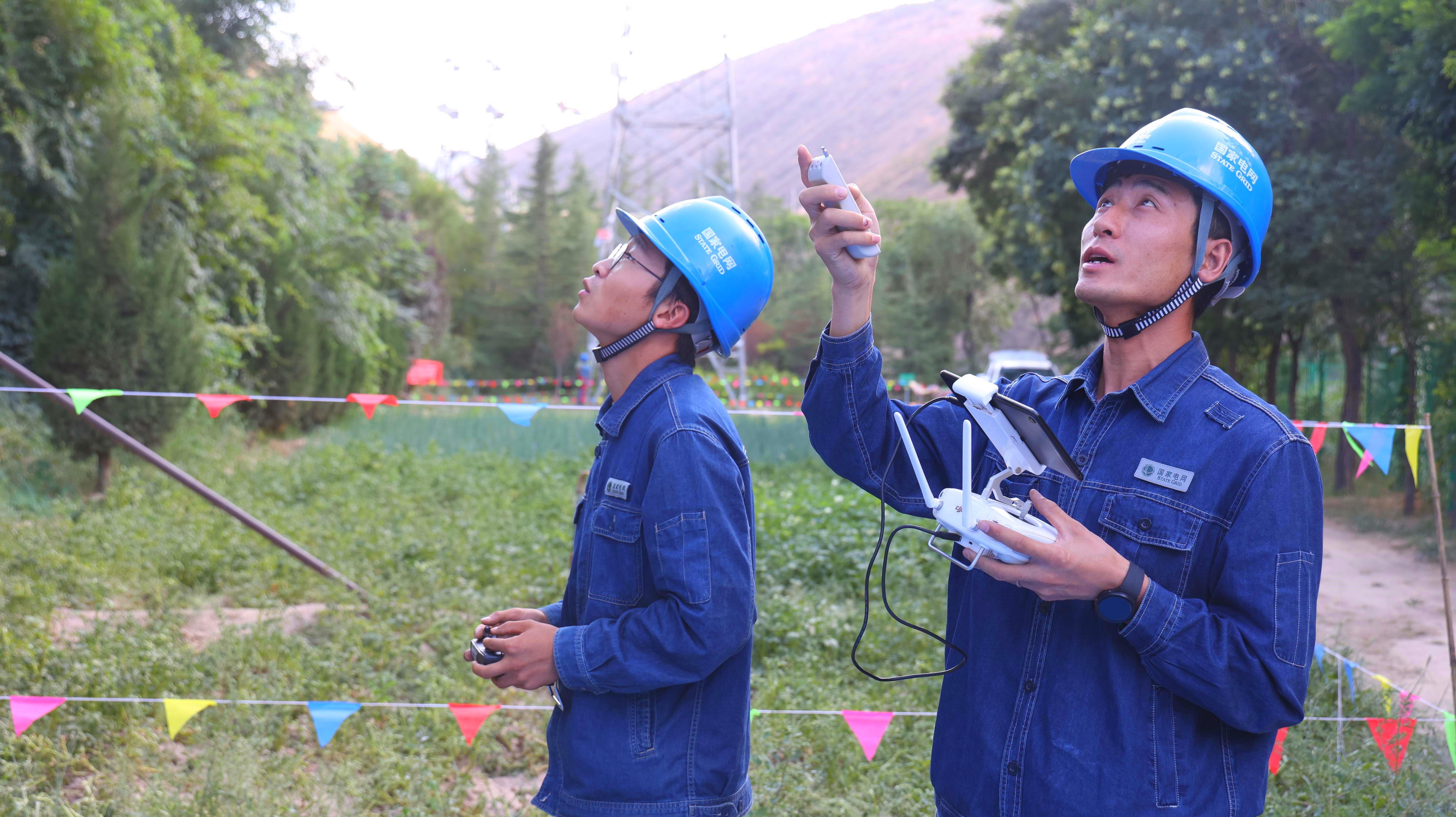 8月25日，國網(wǎng)蘭州供電公司工作人員在蘭州石板山輸電線路技能培訓(xùn)基地使用“‘歐姆雙翼式’無人機(jī)接觸式驗(yàn)電器及接地裝置”完成高空輸電線路的接觸式驗(yàn)電及接地。李小東攝 (1).jpg